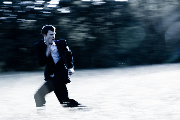 Man running, looking fearfully behind him